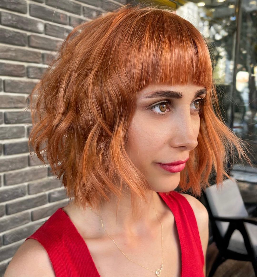 48. Radiant Ginger Waves with a Chic Fringe